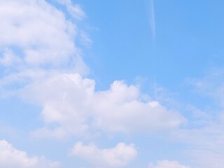 Blue sky background with white clouds in summer. Soft white clouds float in the clear blue sky....