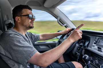 Driver pointing while driving. Man gestures in car. Reaction behind the wheel.