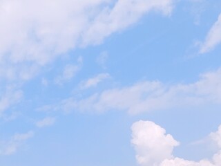 Blue sky background with white clouds in summer. Soft white clouds float in the clear blue sky....