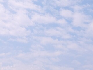Blue sky background with white clouds in summer. Soft white clouds float in the clear blue sky....