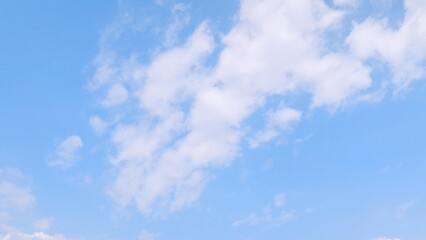 Blue sky background with white clouds in summer. Soft white clouds float in the clear blue sky. Focus on clouds. Full frame shot. Heaven sky bright blue sky background.