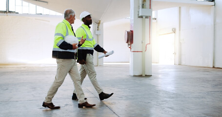 Men, discussion and construction worker at warehouse, inspection or review for safety check at...