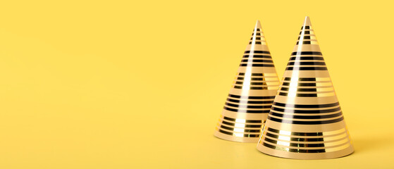 Party hats on yellow background with space for text