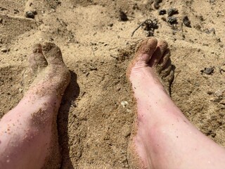 feet in the sand on a sandy beach