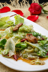 White round porcelain plate with stir-fried lamb and green onions