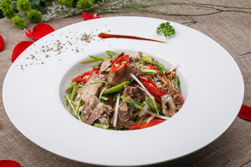 Spicy beef with enoki mushrooms in a stainless steel pot