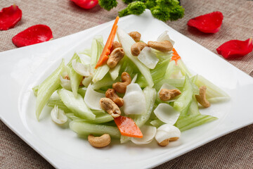 Fried lily bulb with cashews, celery and lily bulbs on a white square porcelain plate