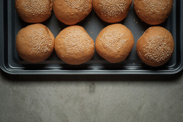 top view photograph shot with a half frame of many burger breads on the oven tray put on rusty...