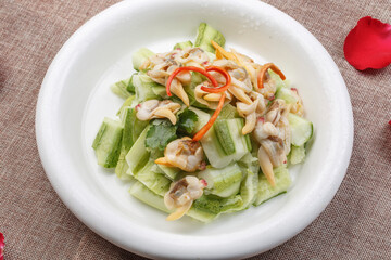 White porcelain plate with fried razor clam meat and rapeseed