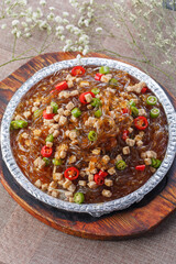 Spicy diced chicken crystal powder in tin foil on wooden pallet