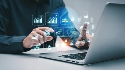 Person using laptop with digital business icons floating above the keyboard and touchpad area - Powered by Adobe