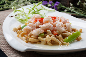 Sauteed shrimp with mushrooms in a sail-shaped white porcelain plate