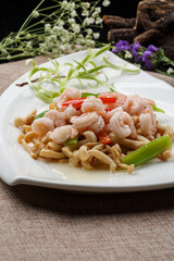 Sauteed shrimp with mushrooms in a sail-shaped white porcelain plate