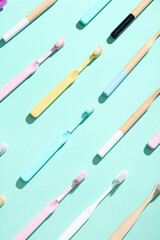 Wooden and plastic colorful toothbrushes on color background.