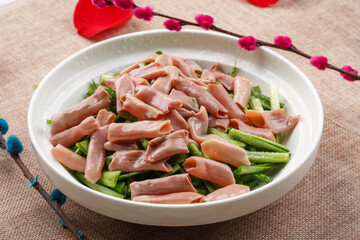 Seafood fried with leeks and sea sausage in a round white porcelain plate