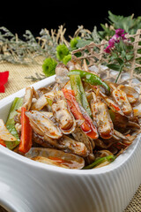 Spicy fried razor clams in a white porcelain plate