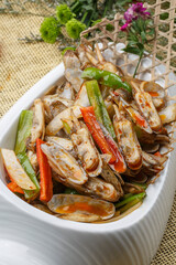 Spicy fried razor clams in a white porcelain plate