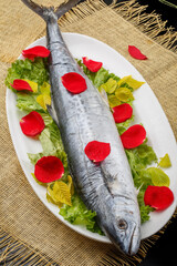 Fresh mackerel in a white oval porcelain plate