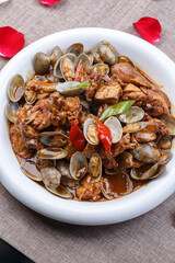 Round white porcelain plate with chicken and clams