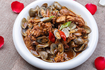 Round white porcelain plate with chicken and clams