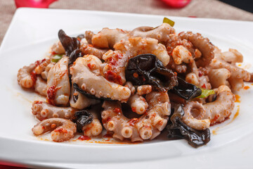 Fried octopus with XO sauce on a white square porcelain plate
