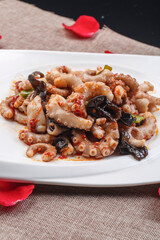 Fried octopus with XO sauce on a white square porcelain plate