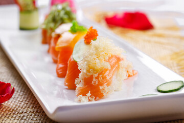 Assorted salmon nigiri sushi on a straw mat