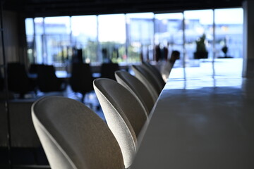 Bar stools and marble bar counter in a modern office interior with shallow depth of field and...