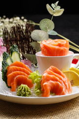 Salmon sashimi is placed on the grass mat