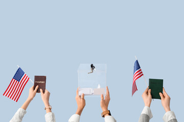 Hands holding ballot box, passports and USA flags on light background. Election concept