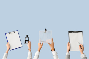 Hands holding ballot box and clipboards with voting papers on light background. Election concept