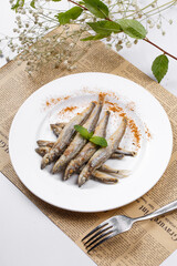 Japanese style grilled salt and pepper capelin placed on English wrapping paper