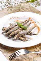 Japanese style grilled salt and pepper capelin placed on English wrapping paper