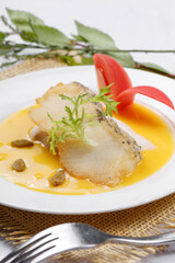 Codfish with French pumpkin sauce served on a straw mat