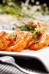 Sizzling South American shrimps on a plate placed on a placemat