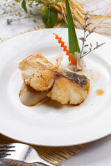 Russian deep sea cod in a white round plate placed on a straw mat