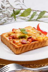 Freshly grilled seafood beef pizza on a white round plate placed on a straw mat