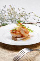 Large scallops and scallops are placed on English wrapping paper