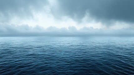 Obraz premium Calm blue ocean under a cloudy, overcast sky