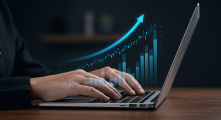 Close-up of hands typing on a laptop keyboard, representing business and technology in the office