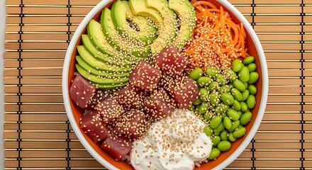Overhead view of a poke bowl with tuna avocado edamame and carrot shreds