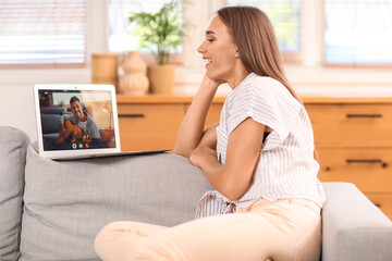 Young woman video chatting with man playing guitar at home