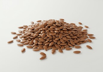 A mound of brown flax seeds is arranged on a white surface, highlighting their natural texture and color