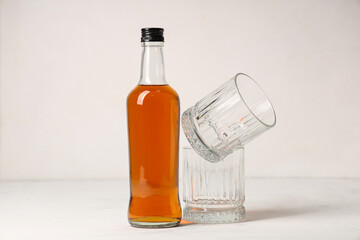 Bottle of rum and glasses on white background