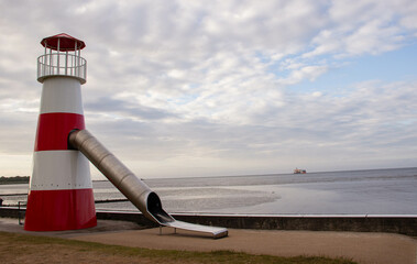 Children’s slide shaped like a lighthouse on the Baltic Sea shore in Germany, combining fun, coastal design, and seaside family recreation.