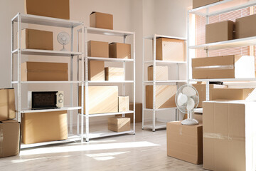 Interior of light warehouse with cardboard boxes on shelving units
