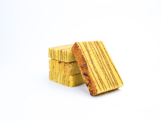 Indonesian layered cake slices (kue lapis legit) stacked on white background. Traditional sweet...