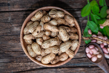 Peanuts in a peel in a wooden bowl. peeled peanut on peanut group on wooden bowl.
