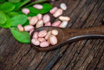 Peanuts in a peel in a wooden bowl. peeled peanut on peanut group on wooden bowl.