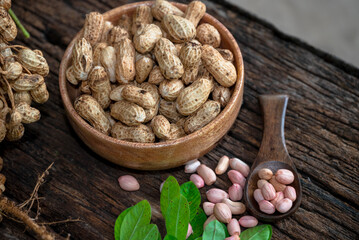 Peanuts in a peel in a wooden bowl. peeled peanut on peanut group on wooden bowl.